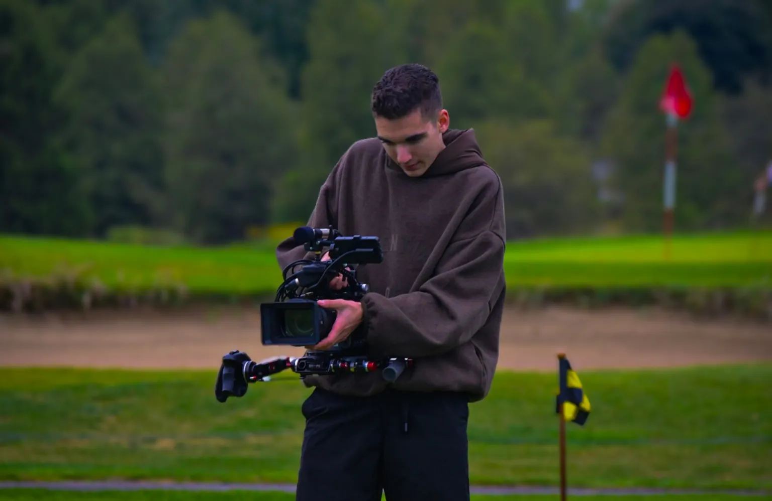 A Production videographer filming on a golf course